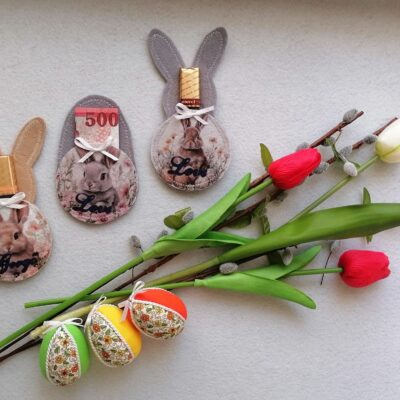 Húsvéti nyuszis ajándéktartók csokival és pénzzel, virágcsokorral és színes tojásdíszekkel.