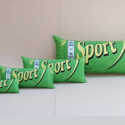 Különböző méretű Sport szelet formájú zöld párnák egymás mellett sorba rendezve, a klasszikus csokoládé dizájnjával, méretkülönbségeket szemléltetve.